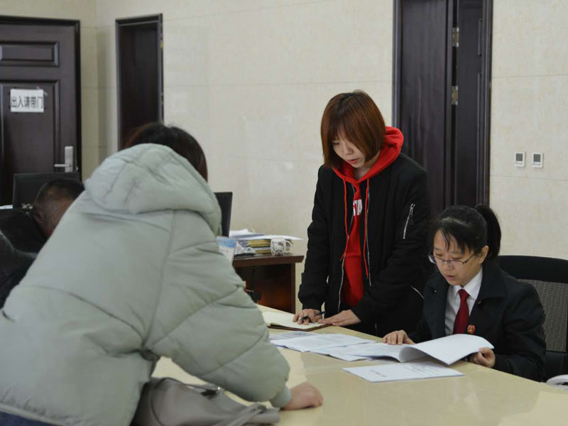 圖四，記者和劉璐一起在立案窗口接待辦事人