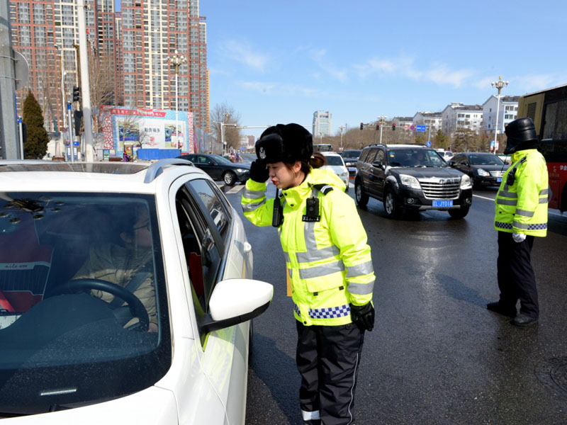 圖四：記者（左一）跟隨民警來到路面，進(jìn)行車輛截查