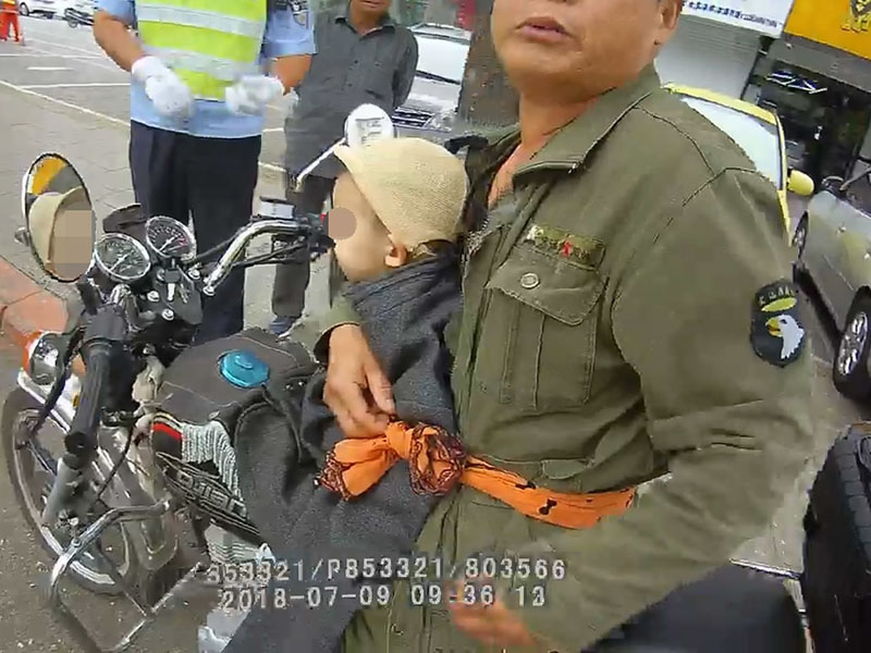 騎摩托車男子僅用一根布條將小男孩固定在自己身上，行駛在馬路上 (2)