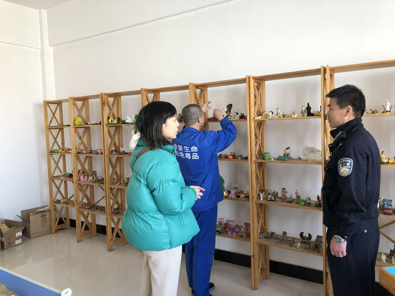 記者（左）與戒毒干警張鵬在沙盤(pán)治療室陪同戒毒學(xué)員張某選擇沙盤(pán)物品