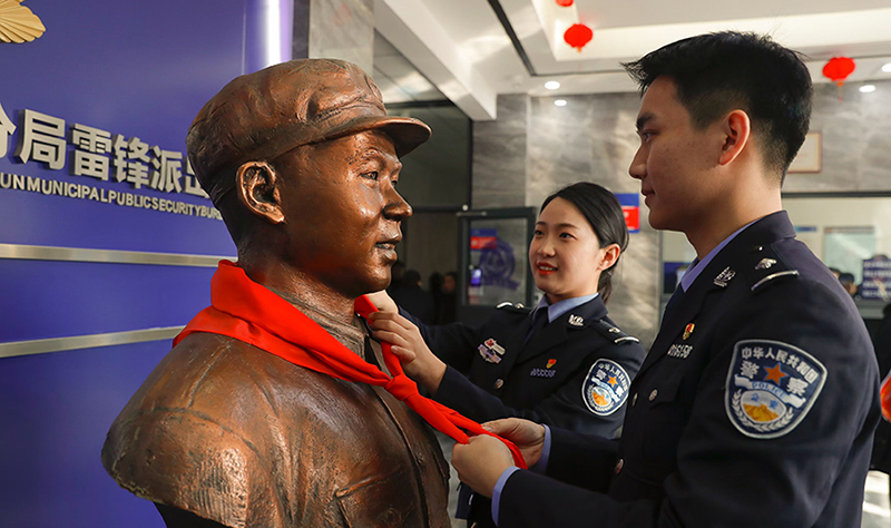 2024年3月5日，撫順市公安局望花分局雷鋒派出所民警白靜（右）和長沙市公安局雷鋒派出所民警韓政霖（左）共同為雷鋒塑像整理紅領(lǐng)巾。