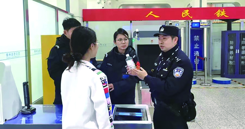 二題圖，童秋華（右）在向旅客講解安檢規(guī)定