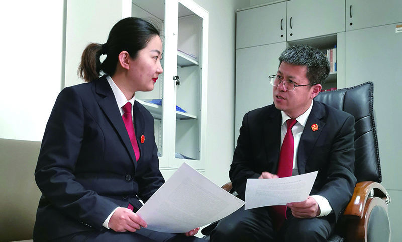 省法院民事審判第三庭庭長董凱（右）就結(jié)項(xiàng)論文內(nèi)容對(duì)楊蒙進(jìn)行指導(dǎo)