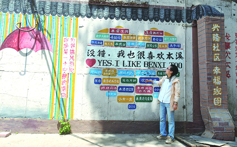 楊軼達向記者介紹社區(qū)的墻繪。
