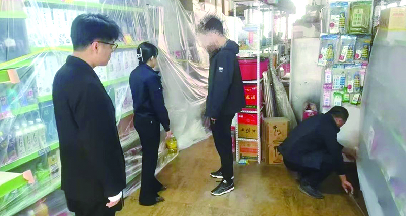 二圖，法院干警正在幫助一樓商戶粘貼防塵塑料布