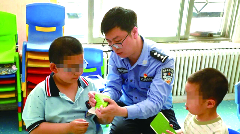 二題圖，民警在營口市金石自閉癥兒童幼兒園指導(dǎo)孩子制作粽子折紙