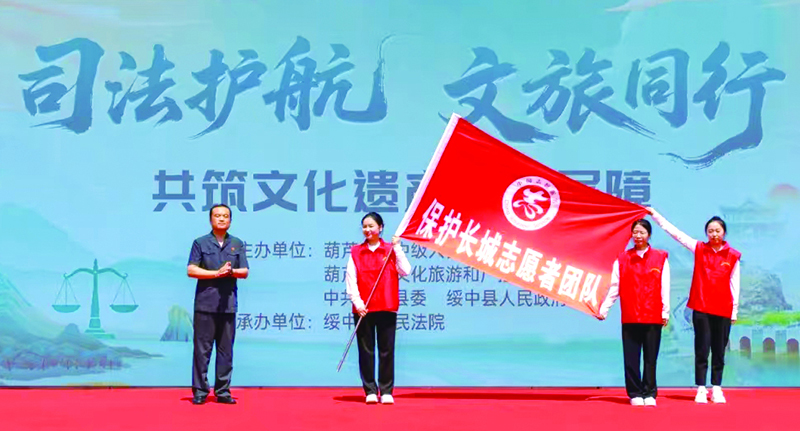為文化遺產(chǎn)保護志愿者團隊授旗