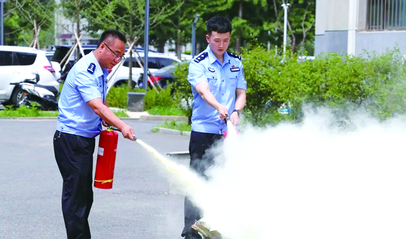 二題圖，民警進行滅火器撲救初期火災(zāi)實操演練。